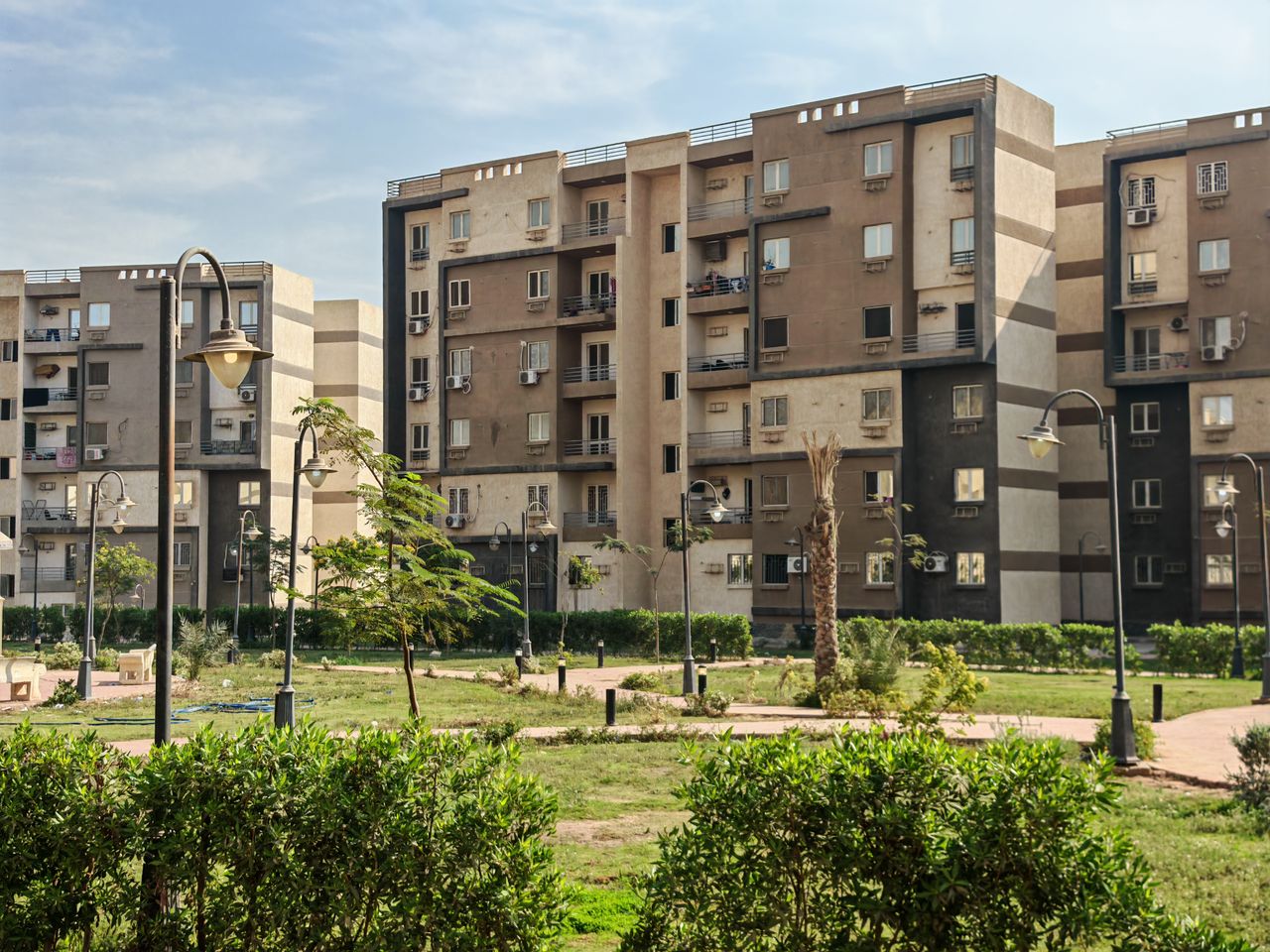 Services A modern residential building complex with lush greenery and public park.