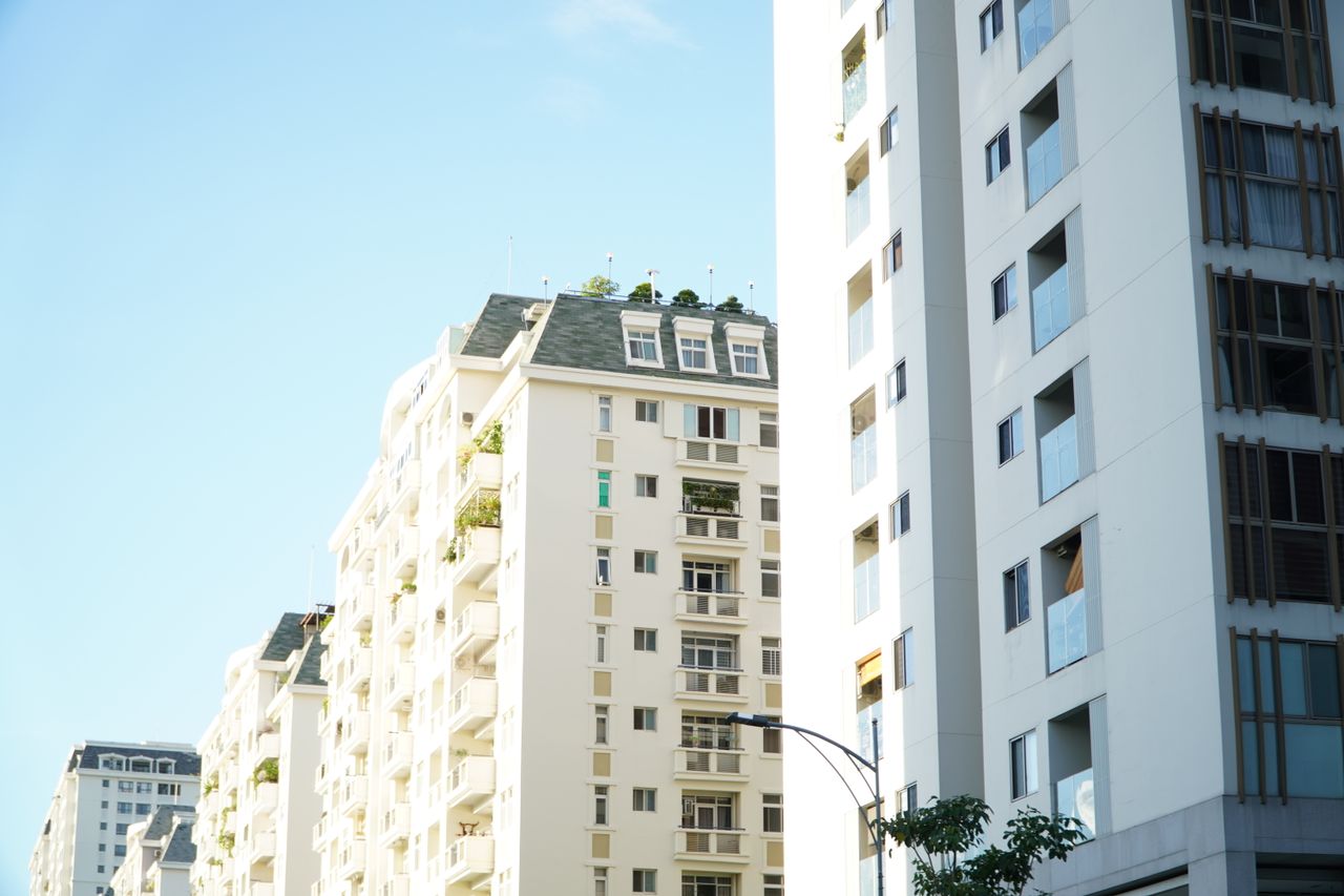 Services Bright day view of white urban residential apartment buildings.
