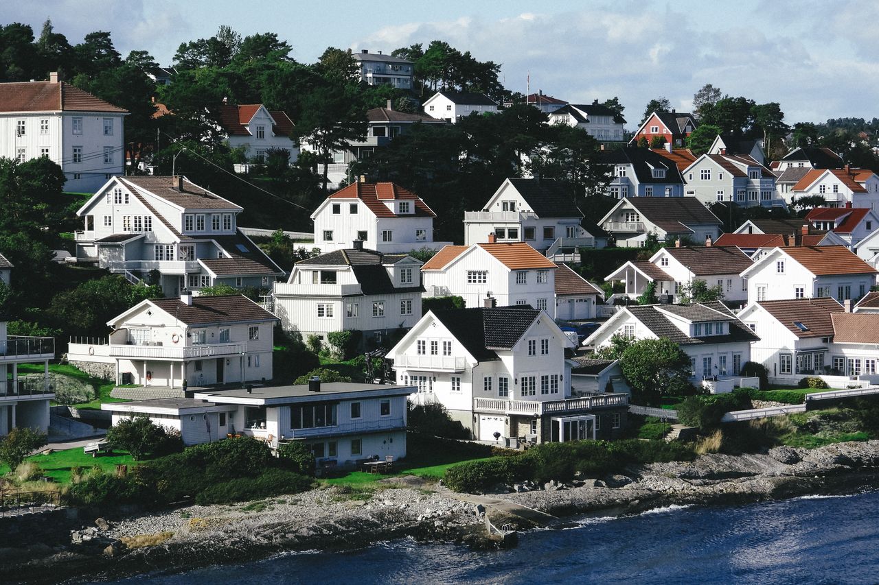 White residential houses located on hill in small town on shore of blue rippling sea